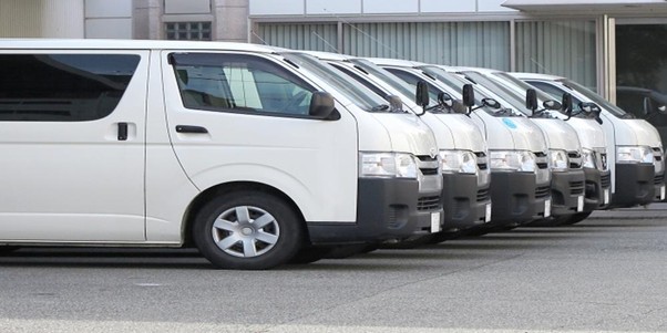 企業の業務用車両が整然と並ぶ駐車場の様子