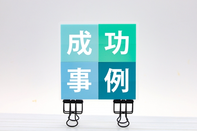 成功事例と書かれた紙とクリップ